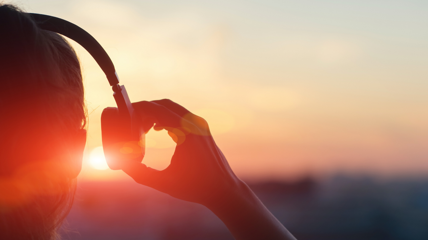 a person listening to music as the sun rises